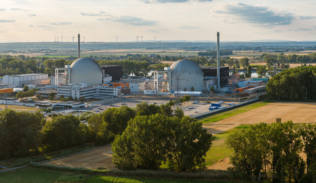 Aerial view of Biblis Nuclear Power Plant with its iconic reactor domes, surrounding industrial facilities, and adjacent agricultural fields in Biblis, Hessen, Germany.