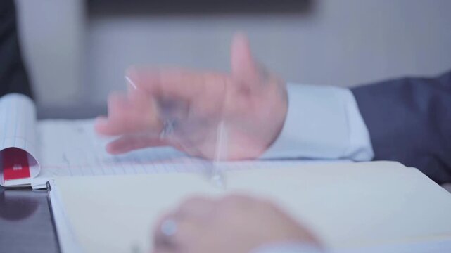 Man tapping pen on files table annoying habit office.