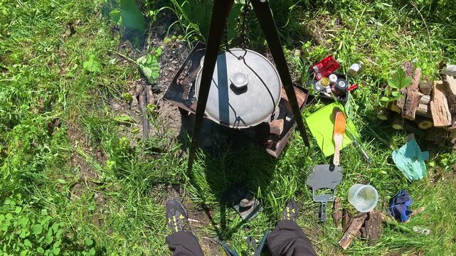 Man covering bograch soup cauldron with lid