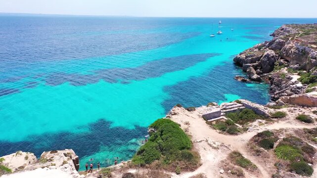 Favignana island coastline, Italy, with boats enjoying the turquoise water. Sicily, Italy