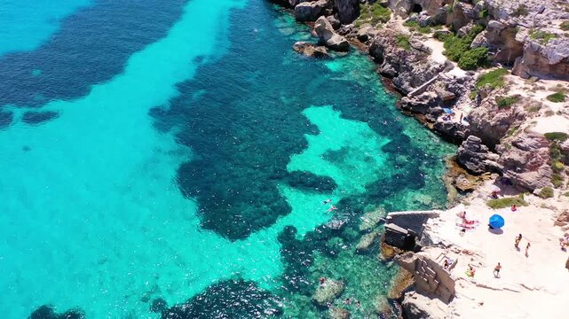 Favignana island coastline, Italy, with boats enjoying the turquoise water. Sicily, Italy