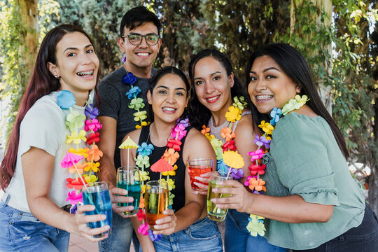 group of latinos friends having a carnival party in a terrace outdoors in Mexico Latin America, portrait of young hispanic multi age people