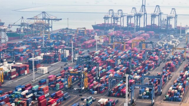 Jakarta, Indonesia - 18 July 2026: Aerial view of Port of Tanjung Priok with rows of colorful shipping containers and large gantry cranes loading cargo ships.