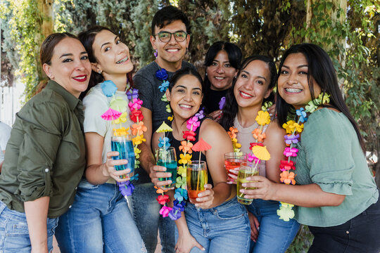 group of latinos friends having a carnival party in a terrace outdoors in Mexico Latin America, portrait of young hispanic multi age people