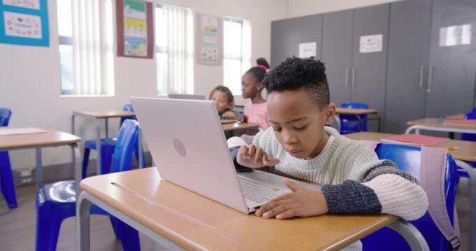 Diverse students working, African American boy seeing laptop leaning tapping doing task in class