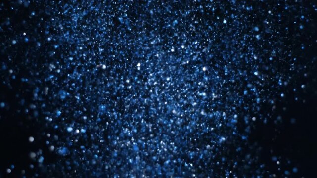 Falling blue glitter particles on black background