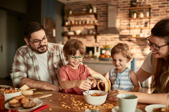 Parents and children making breakfast in home kitchen