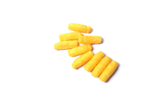 A small pile of crunchy, bright yellow corn puff snacks arranged diagonally on a plain white background.