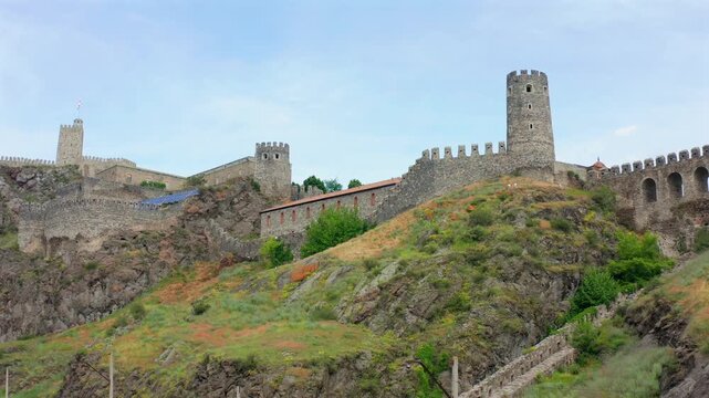 Rabati Fortress approaches in elevated aerial view across stone walls, towers and hillside architecture in Akhaltsikhe, Georgia, supporting heritage tourism, history media and destination promotion.