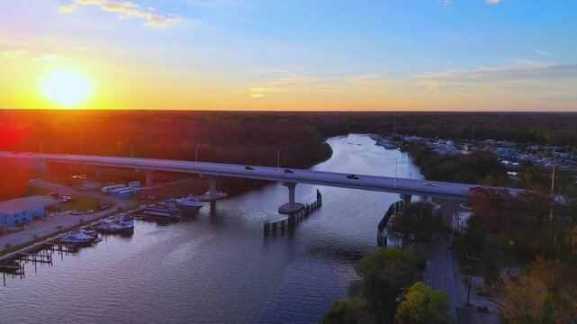 Lake County, Florida, United States - 21 July 2026: Aerial view of Crows Bluff bridge over the St. Johns River at sunset with boats docked at the marina.