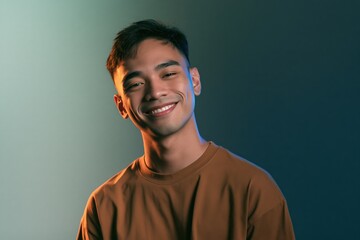 Fototapeta premium Smiling young man headshot with soft blue studio rim light for casual portrait background and profile banner design
