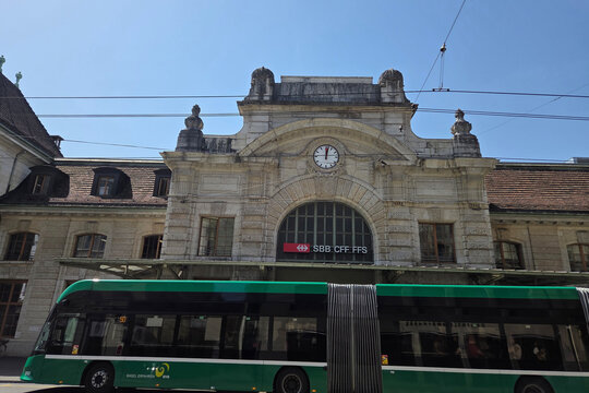 Basel, Switzerland, May 25, 2026: Historic SBB CFF FFS Railway Station Facade with Green Tram in Motion