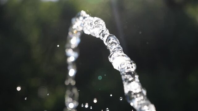 A jet of water flies in the air with splashes. Water drops in the summer.
