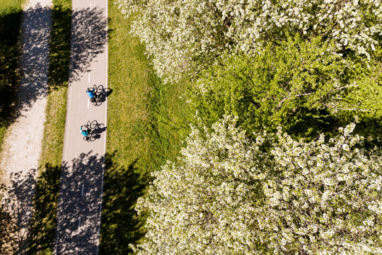 Two cyclists travel along a sunny bike path, enjoying an active lifestyle and spring nature exploration on the scenic Alpe Adria route, Julian Alps,Tarvisio,Camporosso,Friuli Venezia Giulia,Italy.