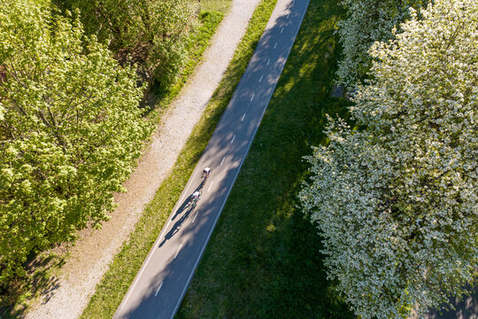 Cycling, outdoor adventure lifestyle with two people riding bicycles on a path in nature, in the Julian Alps, Tarvisio, Camporosso, Friuli Venezia Giulia, Italy rural area.