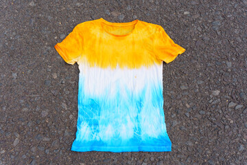 Tie-dye t-shirt with yellow and blue ombre pattern on white background © Katie Chizhevskaya