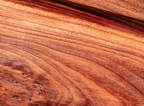 Reddish brown bubinga wood grain texture background close up