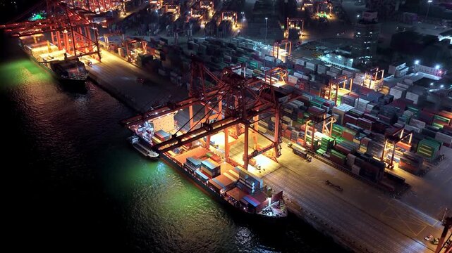 Unloading large cargo containers seaport. Loading freight sea port. Top aerial drone view. Lot big boxes rows, ship delivery ocean harbor. Shipping night. Goods export import. Industrial Marine dock.