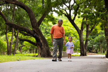 Obraz premium walking, Asian girl and grandfather walk outdoor for child development or growth. Adventure, excited and path with happy kid in nature park for outdoors activity. Healthy outdoor sport for kids.