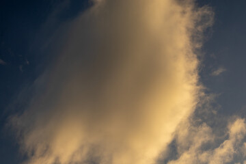 Fototapeta premium Golden Cloud Against a Dark Blue Sky