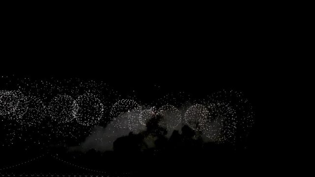 Dazzling silver fireworks exploding across the night sky, sparkling aerial pyrotechnics display with glowing smoke, festive celebration and spectacular cinematic atmosphere