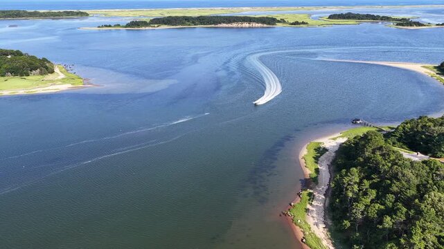 A fast boat cruises through Pleasant Bay on Cape Cod, Massachusetts. This beautiful coastal area is a popular summer vacation destination for people from all over the world.