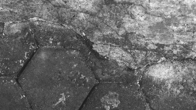 Black and white concrete and hexagonal paving texture with worn surface, urban abstract background featuring weathered stone and cement details.