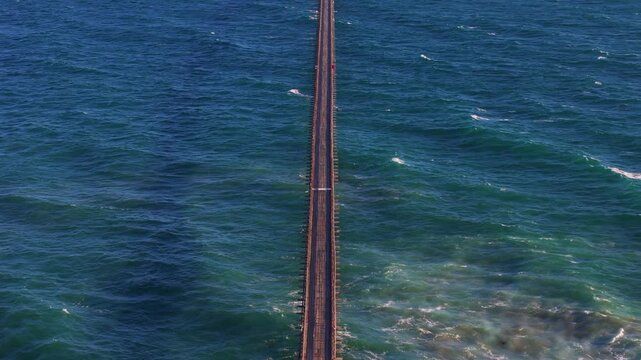 Ventura County, California - 15 July 2026: Aerial view of the long causeway leading to Rincon Island, surrounded by the deep blue waters of the Pacific Ocean.