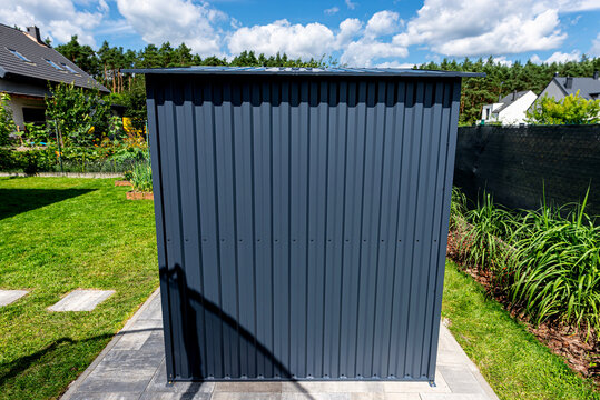Modern corrugated metal garden shed in backyard