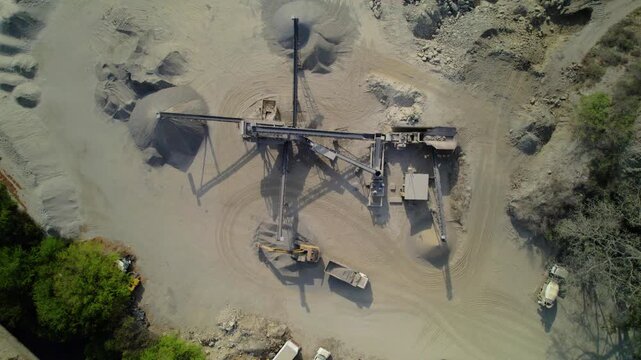 La Guaira, Venezuela - 16 April 2025: Aerial view of a quarry site with conveyor belts, piles of gravel, and heavy machinery.