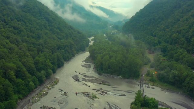 Aragvi River winds through aerial view across a misty forest valley in Georgia, supporting watershed research, floodplain mapping, ecotourism promotion and regional environmental documentaries.