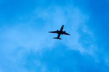 Fototapeta premium Airplane flying above blue sky with clouds during daytime