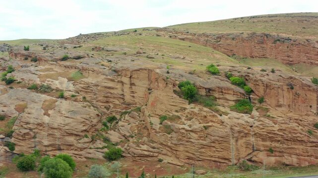 Uplistsikhe formations fill aerial view above carved chambers and dry Georgian hills, supporting archaeological tourism, ancient history, geology education, site conservation and heritage promotion.