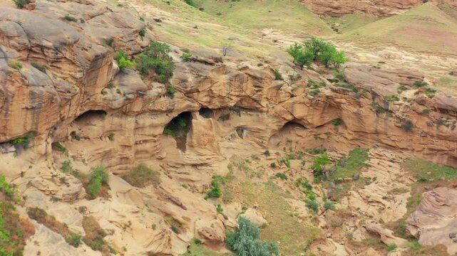 Ancient cave chambers fill aerial view across the eroded rock slopes of Uplistsikhe near Gori, supporting archaeology, heritage tourism, rock architecture and Georgian history documentaries.