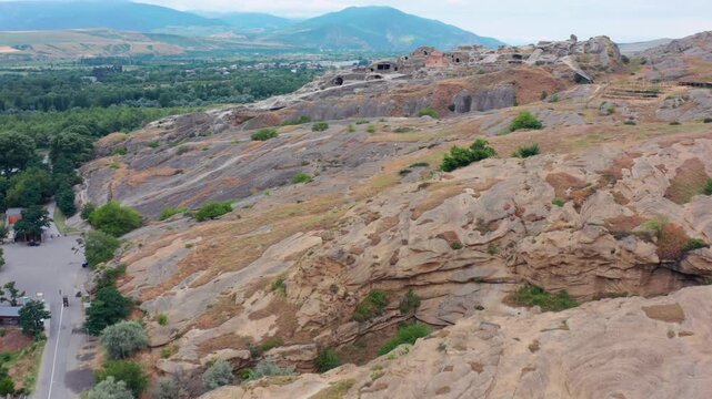 Uplistsikhe cave city fills aerial view above rock-cut halls and the Mtkvari valley, supporting Georgian tourism, archaeological research, cultural heritage and regional destination marketing.