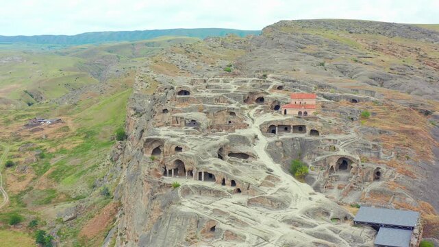 Uplistsikhe cave town fills aerial view over rock-cut dwellings and exposed terraces near Gori, supporting ancient history, archaeological tourism, heritage media and Georgian destination marketing.