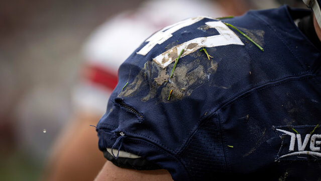 Close-up of a Muddy American Football Jersey Shoulder with Grass Stains After an Intense Game