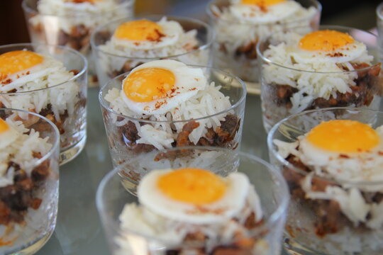 Peruvian arroz tapado with quail egg served in shot glasses