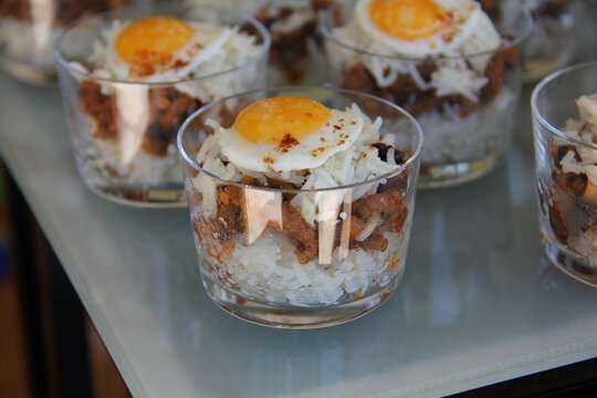 Peruvian arroz tapado with quail egg served in shot glasses