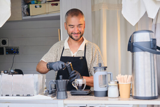 Barista sonriendo mientras prepara caf&eacute; de especialidad en una cafeter&iacute;a m&oacute;vil
