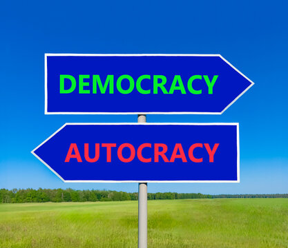Democracy or autocracy words symbol. Concept words Democracy Autocracy on beautiful blue road sign. Beautiful blue sky background. Business democracy autocracy concept. Copy space