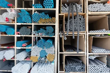 Plastic pvc pipes and thermal pipe insulation stored on shelves in hardware store warehouse © seregraff