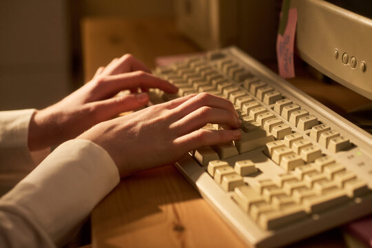 Close up of young adult woman hands typing on desktop keyboard, working at computer workstation. Suitable for office productivity, data entry, remote work marketing