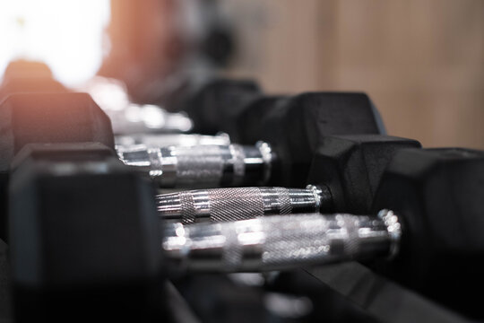 Close up dumbbells in gym fitness center, strength training and bodybuilding equipment concept, workout motivation for healthy lifestyle, exercise routine and sports training background.