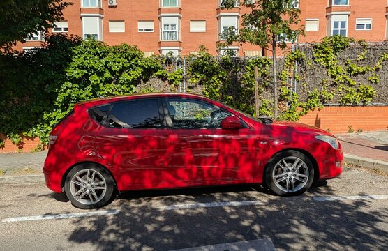 Vista lateral de un autom&oacute;vil Hyundai i30 de color rojo aparcado en una calle de Madrid, Espa&ntilde;a, 26 de mayo de 2026