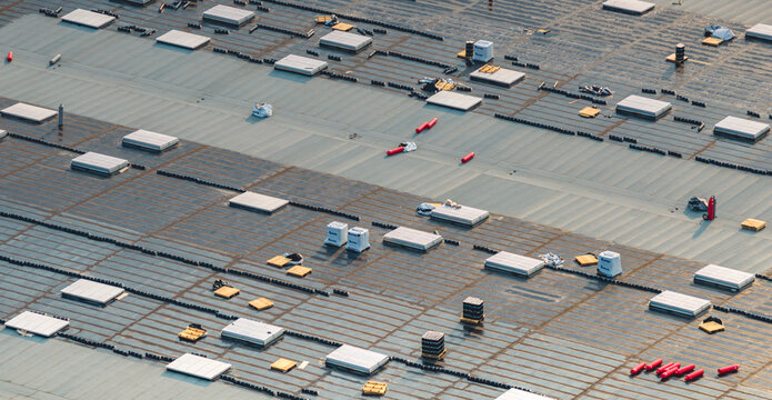 Loriol-sur-Drome, Auvergne-Rhone-Alpes, France - 26 July 2026: Aerial view of a modern industrial warehouse under construction, showing roofing works, skylights, and waterproofing membrane.