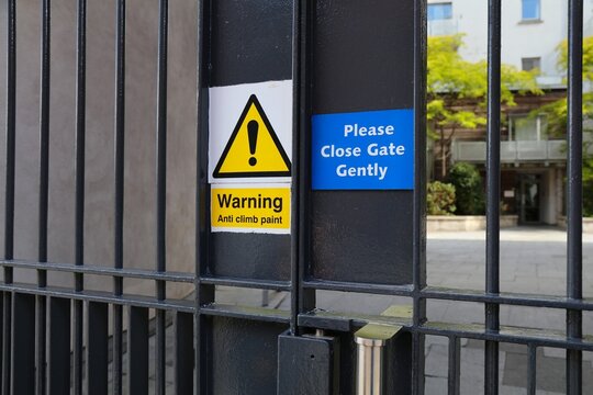 Anti climb paint warning on a property gate in Dublin, Ireland. Residential area noise protection with request to close gate gently.