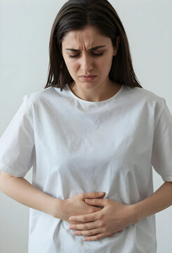 Young woman experiencing stomach pain or menstrual cramps, hands holding abdomen, discomfort and health issues