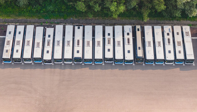 Loriol-sur-Drome, France - 26 July 2026: Aerial view of a fleet of modern public transport buses parked in parallel at a depot, showcasing urban mobility and infrastructure.