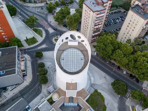 Alges, Portugal - 25 July 2026: Aerial view of the Santissima Trindade Church, featuring its distinctive cylindrical white architecture, glass roof, and surrounding urban streets.